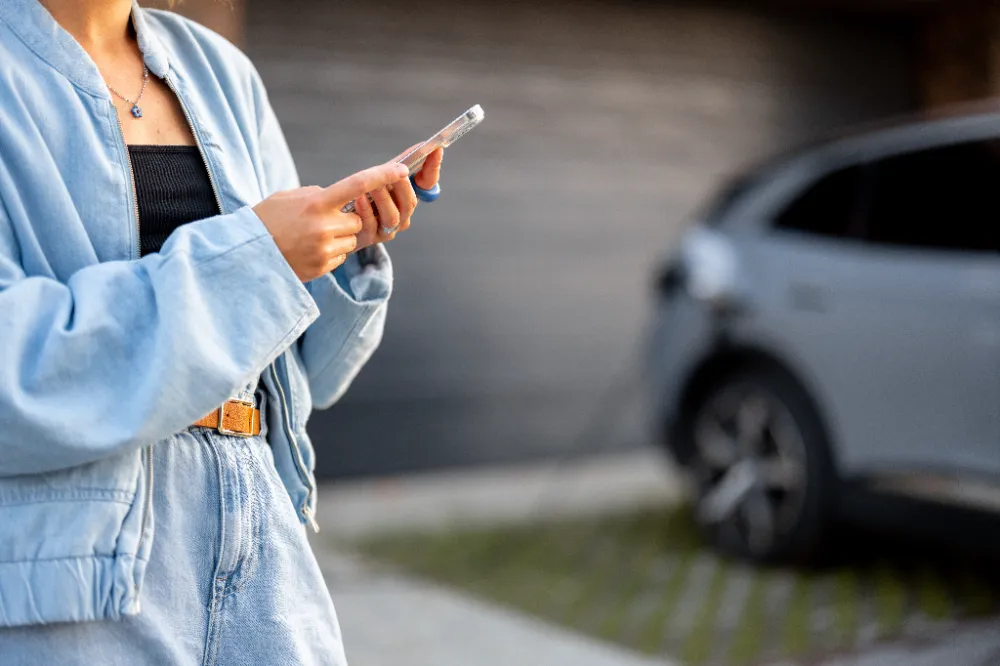 Woman plugging in an electric vehicle outside a Minden, Nevada home, showing convenient at-home EV charging.  