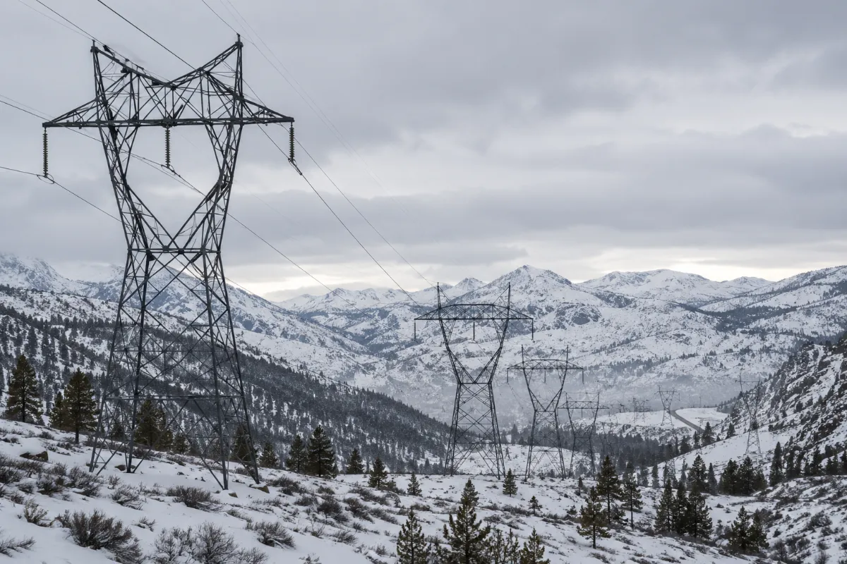 High-voltage transmission lines crossing snowy Sierra Nevada terrain